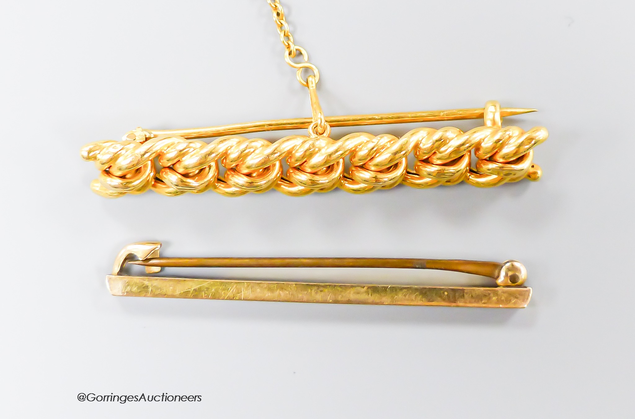 An Edwardian 15ct woven bar brooch, 47mm, 5.4 grams and a 9ct bar brooch, gross 1.1 grams.